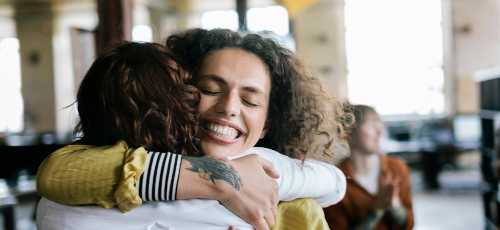 Two women hugging each other